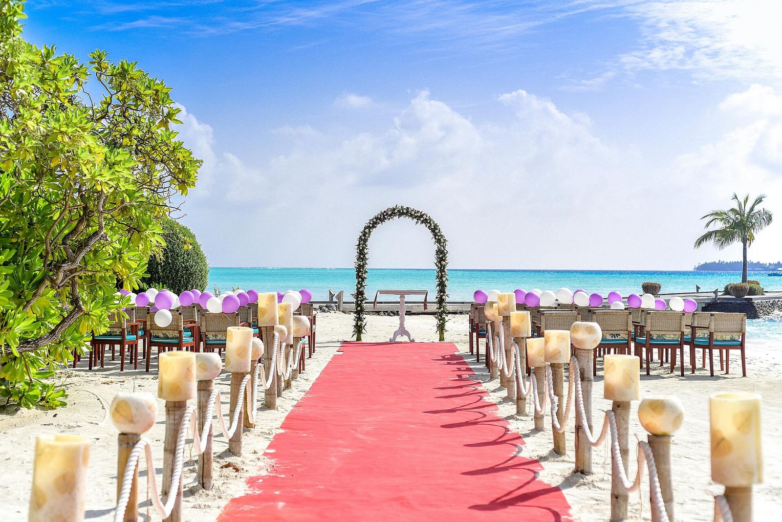 Lorong karpet merah menuju gerbang bunga untuk pernikahan di pantai Bali