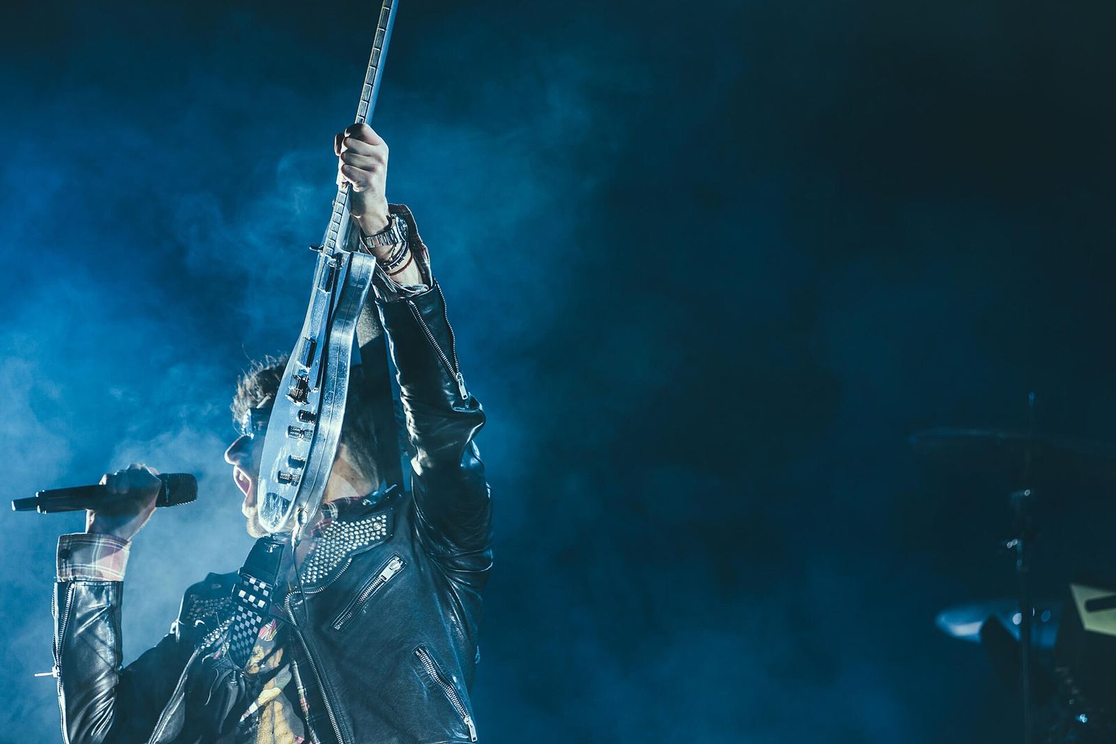 Gitaris band tampil di panggung bercahaya biru