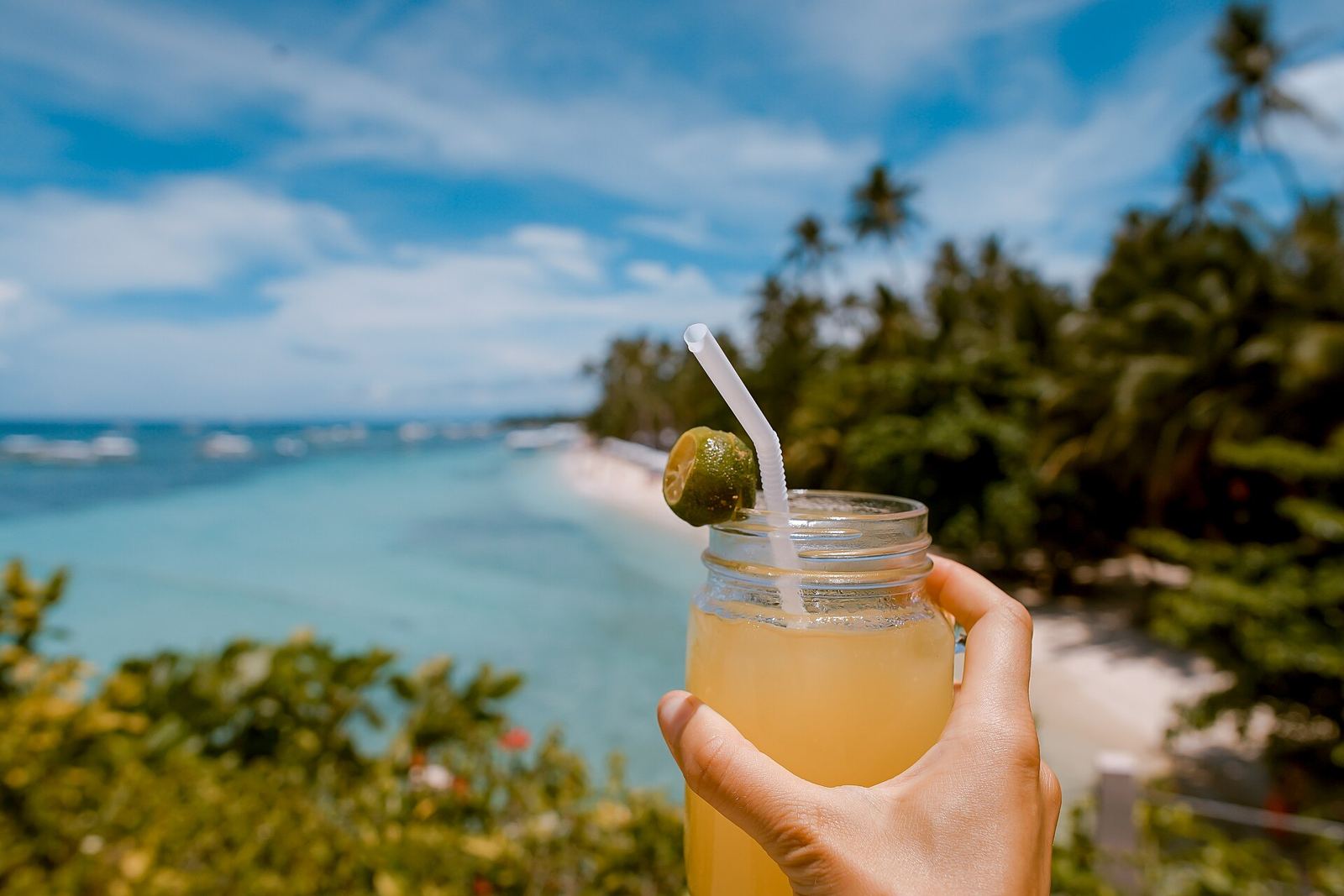 Minuman segar dengan latar pantai tropis